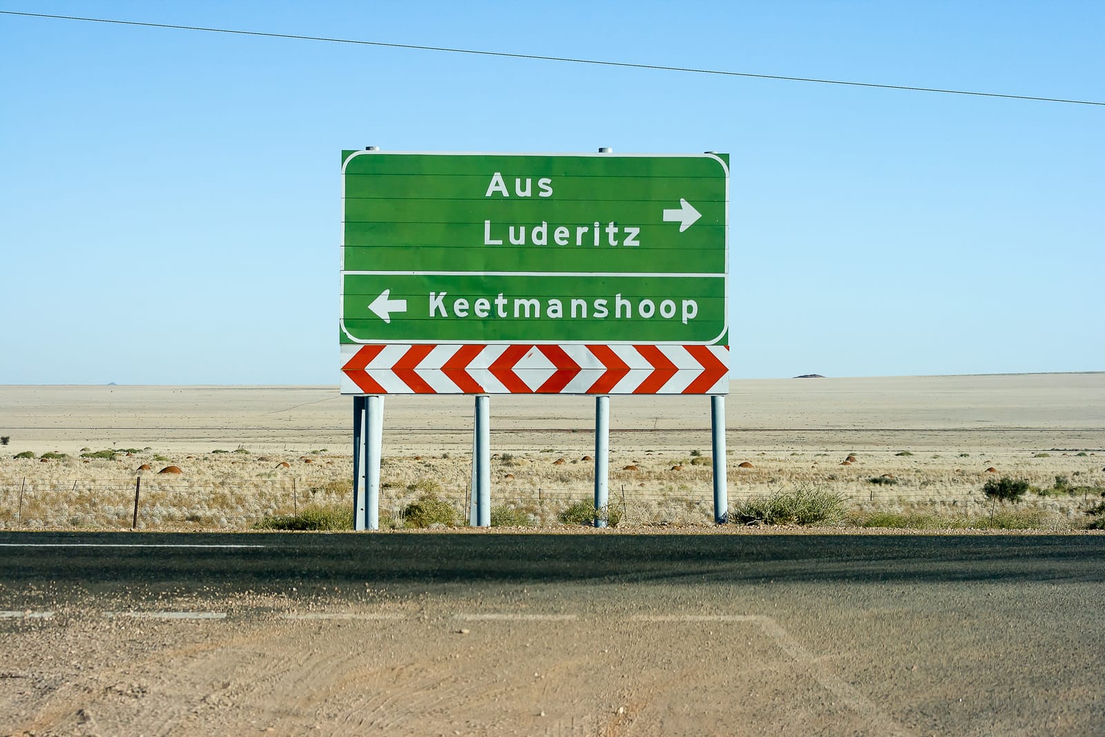 Grüner Wegweiser nach Aus, Lüderitz und Keetmanshoop am Rand einer Steppe